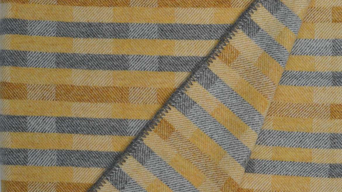 'Lineal' throw in soft ochre yellows and grey