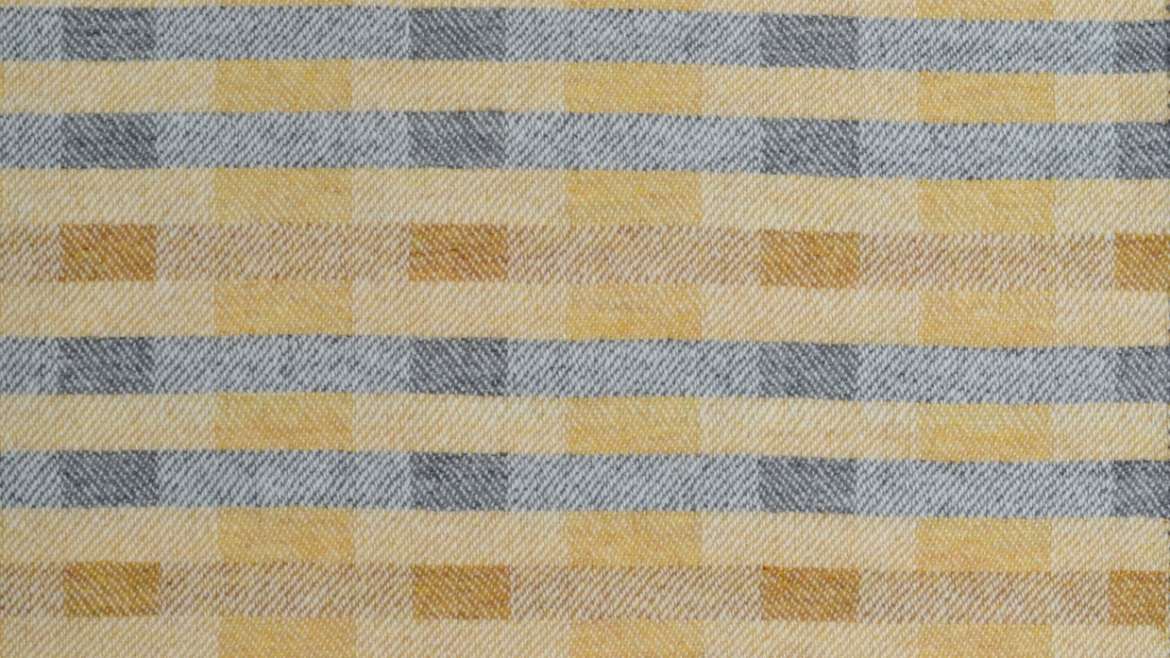 'Lineal' throw in soft ochre yellows and grey